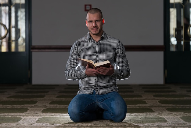 Young Muslim Guy Reading The Koran