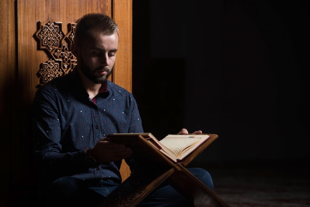 Young Muslim Guy Reading The Koran