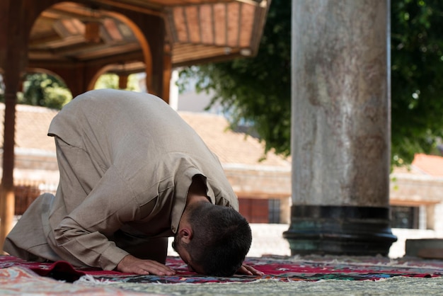 Young Muslim Man Making Traditional Prayer To God While Wearing A Traditional Cap Dishdasha