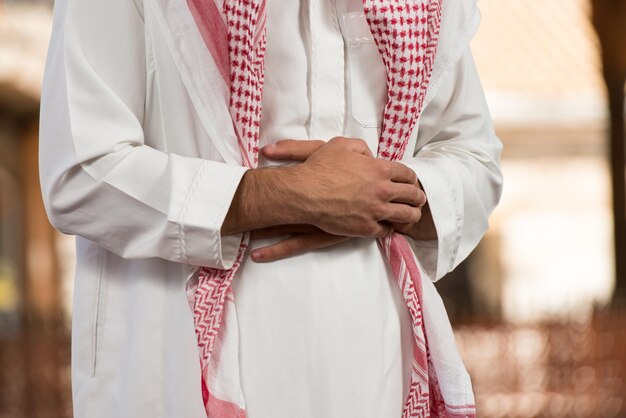 Young Muslim Man Making Traditional Prayer To God While Wearing A Traditional Cap Dishdasha