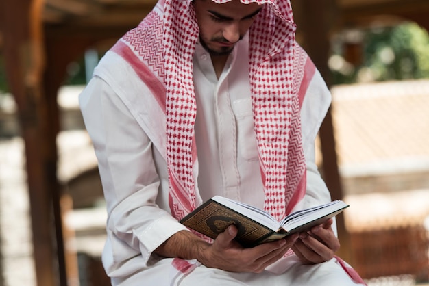 Young Muslim Man Making Traditional Prayer To God While Wearing A Traditional Cap Dishdasha