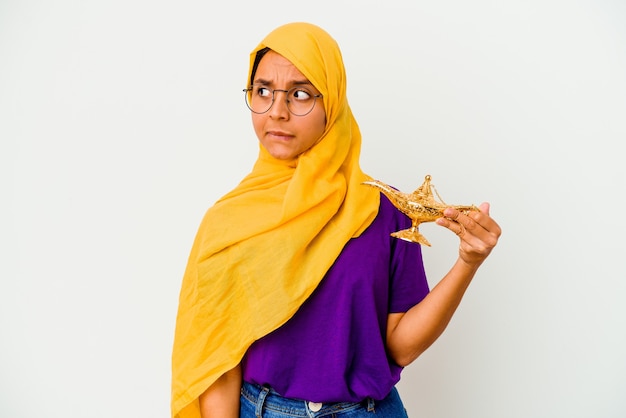 Young muslim woman holding a lamp isolated