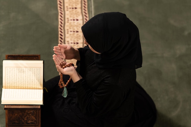 Photo young muslim woman is praying in the mosque