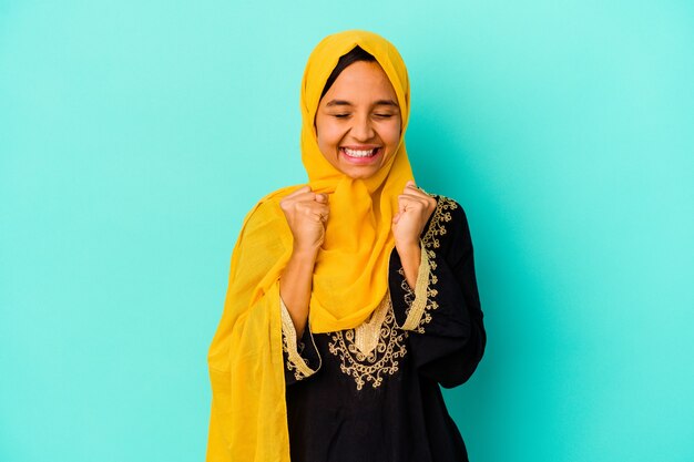 Photo young muslim woman isolated as victory concept