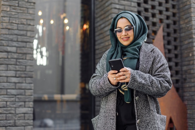 Young muslim woman looking in a smartphone