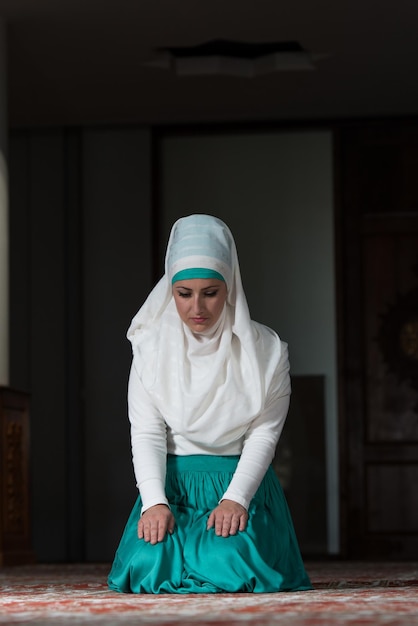 Фото Молодая мусульманка молится в мечети