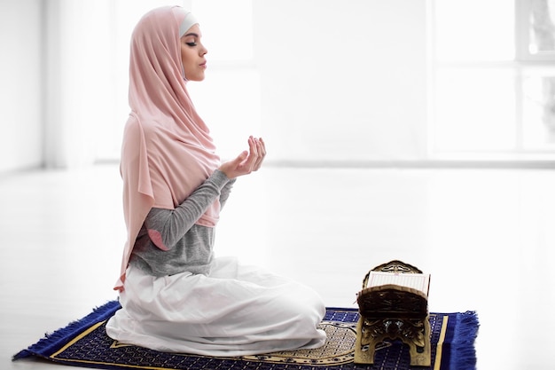 Photo young muslim woman praying indoors