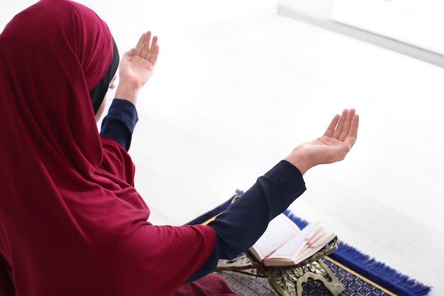 Young Muslim woman praying indoors