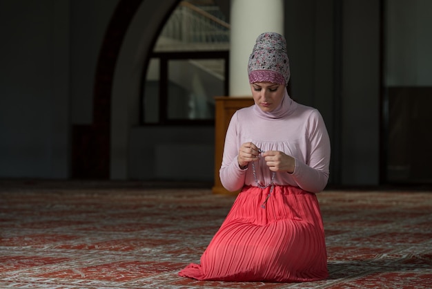 모스크에서 기도하는 젊은 이슬람 여성
