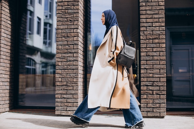 거리에서 걷는 젊은 무슬림 여성 학생