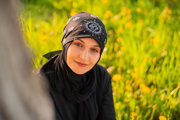 Young Muslim woman wearing hijab at park on a sunny day