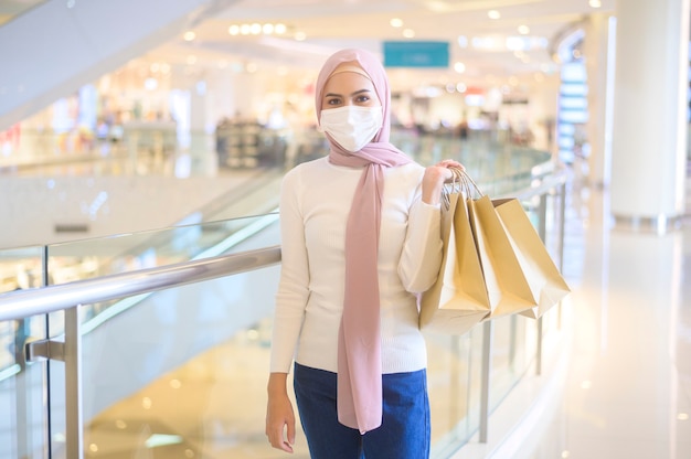 A young muslim woman wearing protective mask in shopping mall