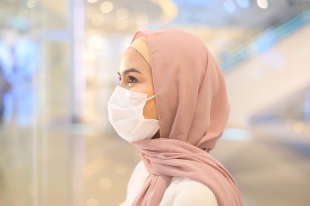 ショッピングモールで保護マスクを着用した若いイスラム教徒の女性