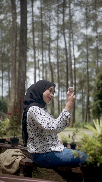 Молодая мусульманка, которая разговаривает по видеосвязи со своим другом
