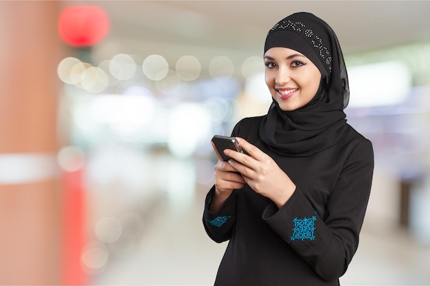 Young muslim woman with book on white