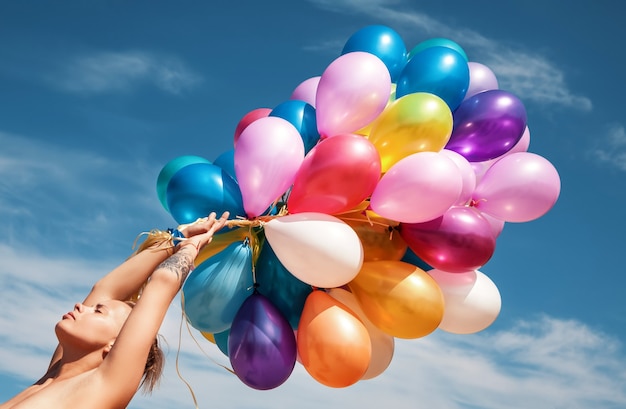 Foto giovane donna nuda sulla spiaggia con palloncini colorati