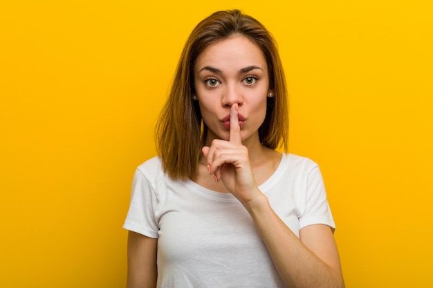 Young natural caucasian woman keeping a secret or asking for silence.