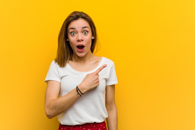 Young natural caucasian woman pointing to the side