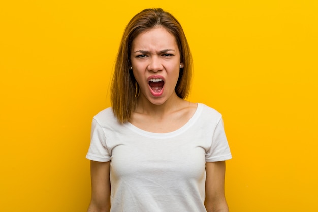 Young natural caucasian woman screaming very angry and aggressive.