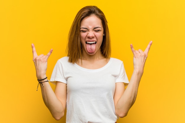 Young natural caucasian woman showing rock gesture with fingers