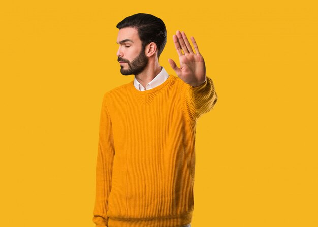 Young natural man putting hand in front