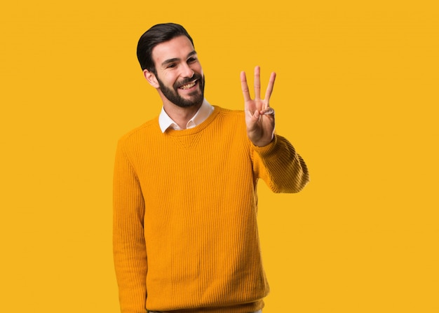 Young natural man showing number three