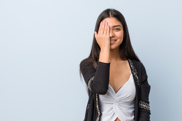 Young natural and pretty arab woman having fun covering half of face with palm.