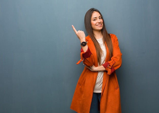 Young natural woman pointing to the side with finger