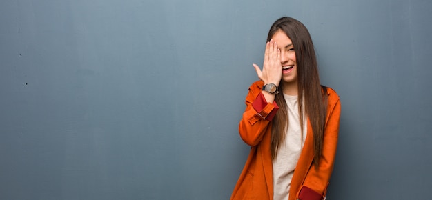 Young natural woman shouting happy and covering face with hand