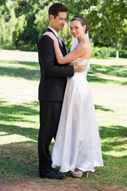 Young newly wed couple embracing in garden