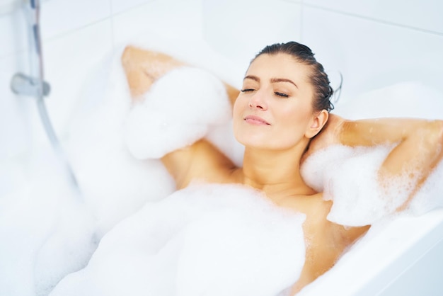 Young nice brunette woman having bath in bathtub High quality photo