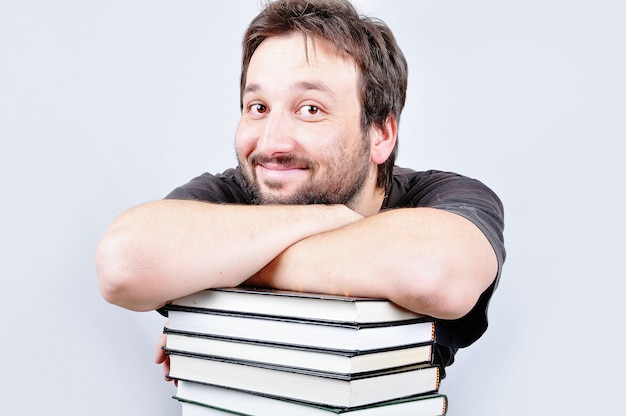 A young nice male is smiling on books