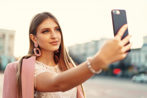 Young nice woman making selfie in the street