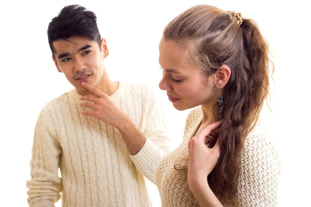 Young nice woman with young attractive man with black hair in white sweaters and jeans standing