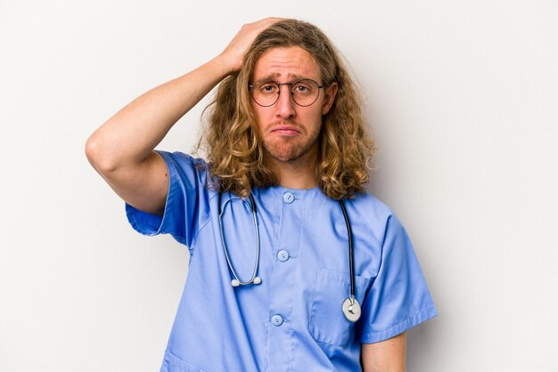 Young nurse caucasian man isolated on blue background being shocked she has remembered important meeting