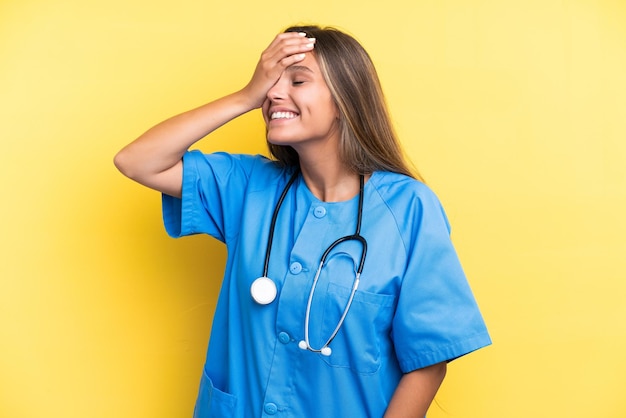 Photo young nurse caucasian woman isolated on yellow background smiling a lot