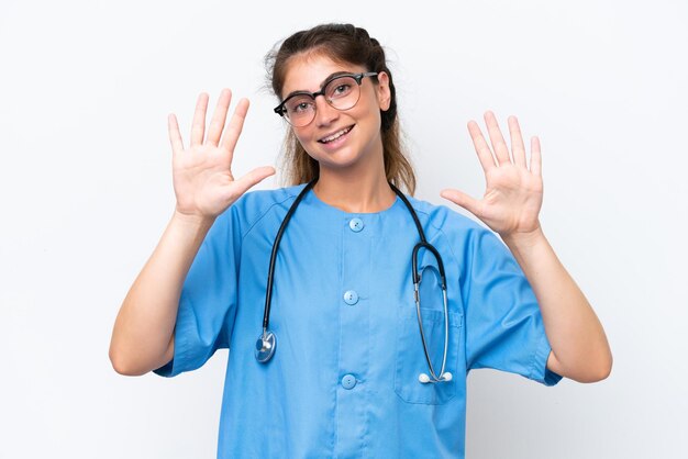 젊은 간호사 의사 여성은  바탕에 고립되어 손가락으로 10을 세고 있습니다.