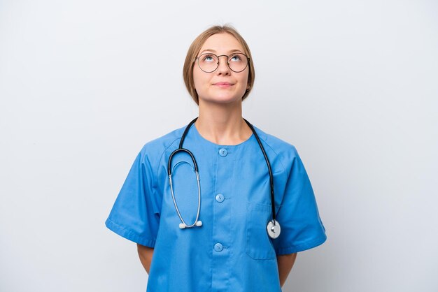 Young nurse doctor woman isolated on white background and looking up