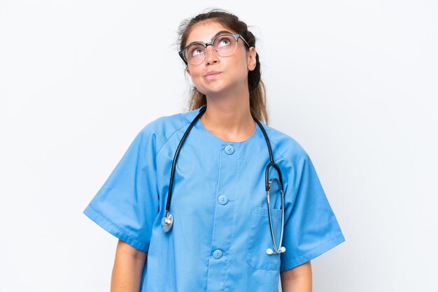 Young nurse doctor woman isolated on white background and looking up