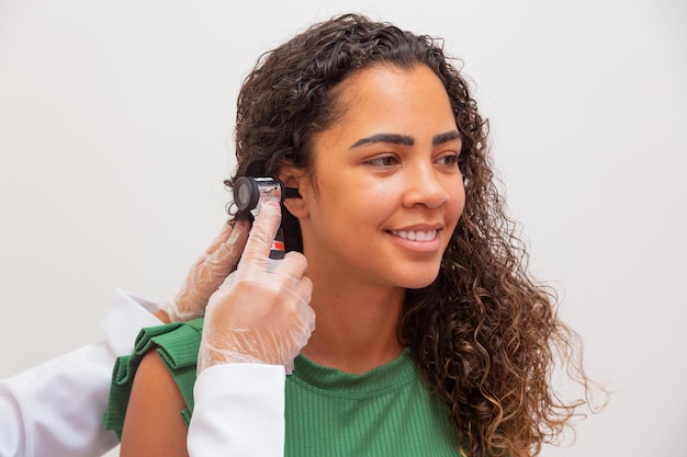 아프리카 환자의 귀를 검사하는 젊은 간호사