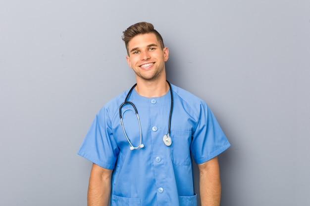 Young nurse man happy, smiling and cheerful.