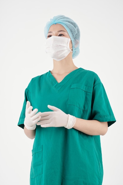 Young nurse in scrubs and protective mask explaining something to patients