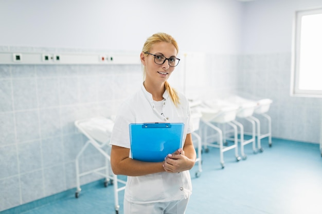 Молодая медсестра, стоящая в родильном отделении.