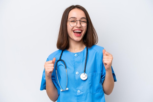 Young nurse Ukrainian woman isolated on white background celebrating a victory in winner position