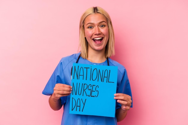 분홍색 배경에 고립 된 국제 간호사 여자 배너를 들고 젊은 간호사 여자