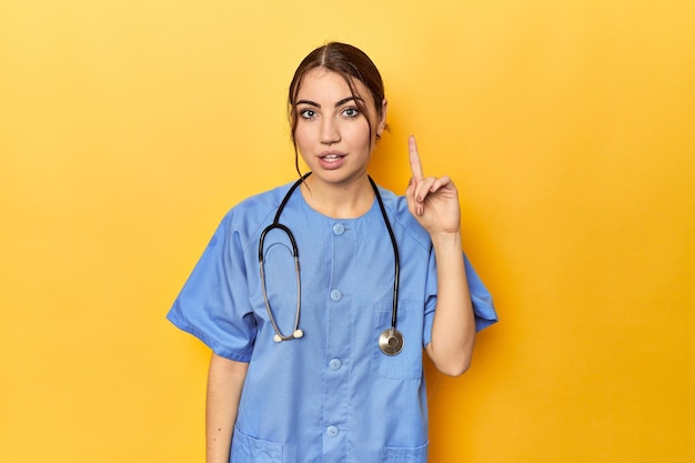 Young nurse in a yellow studio having an idea inspiration concept