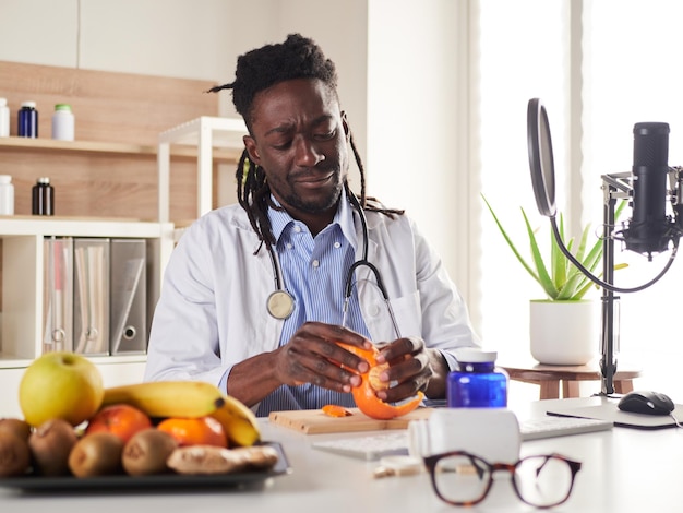 Young nutritionist take a break in office and eat a tangerine