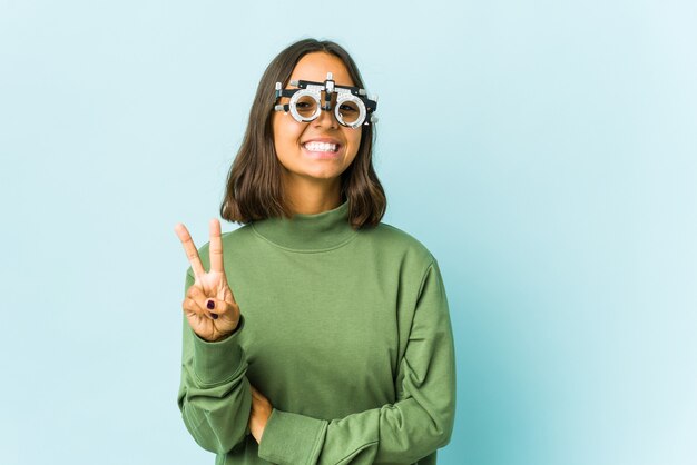 Young oculist woman over isolated wall showing number two with fingers