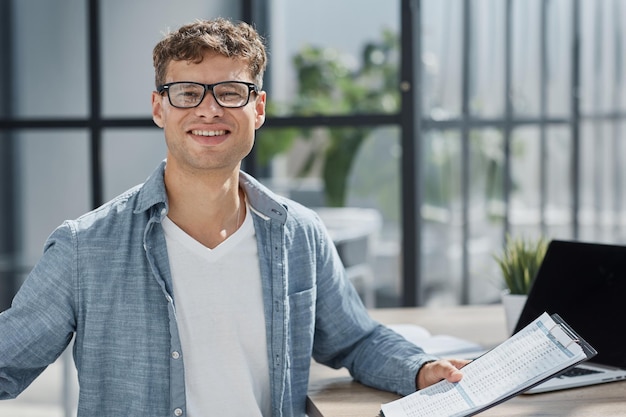 Young office man at workplace making notes