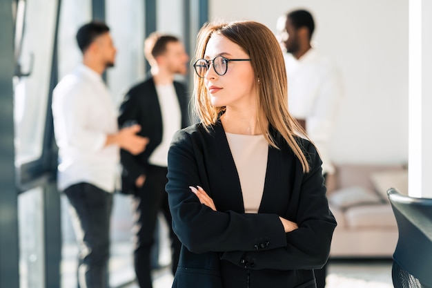 Young office worker and her colleagues